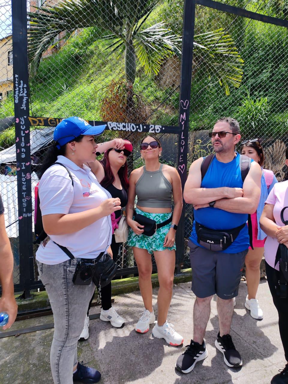 Guide explaining the history of Comuna 13 to a small group