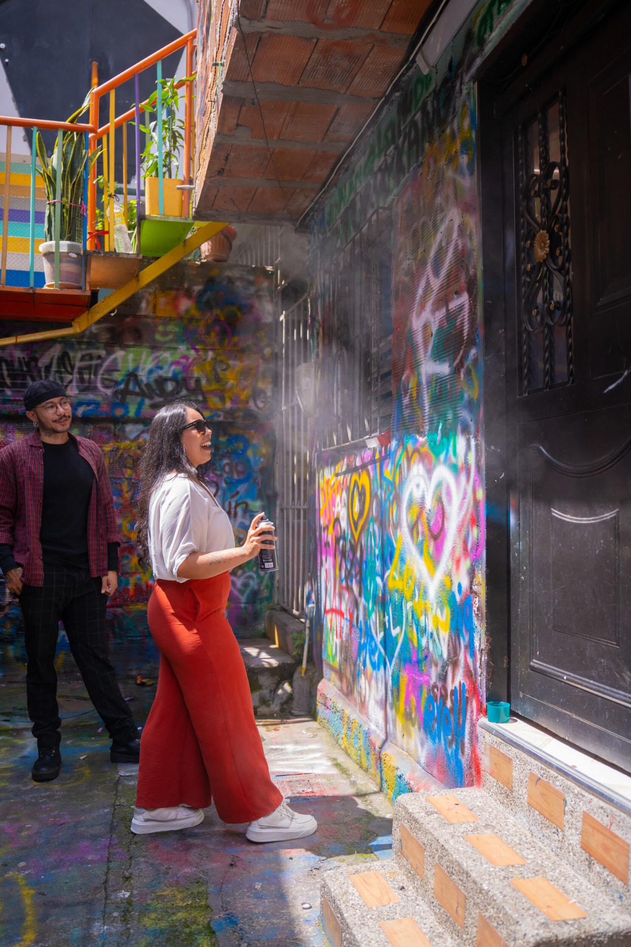 Visitor spray-painting a graffiti wall during the Comuna 13 tour