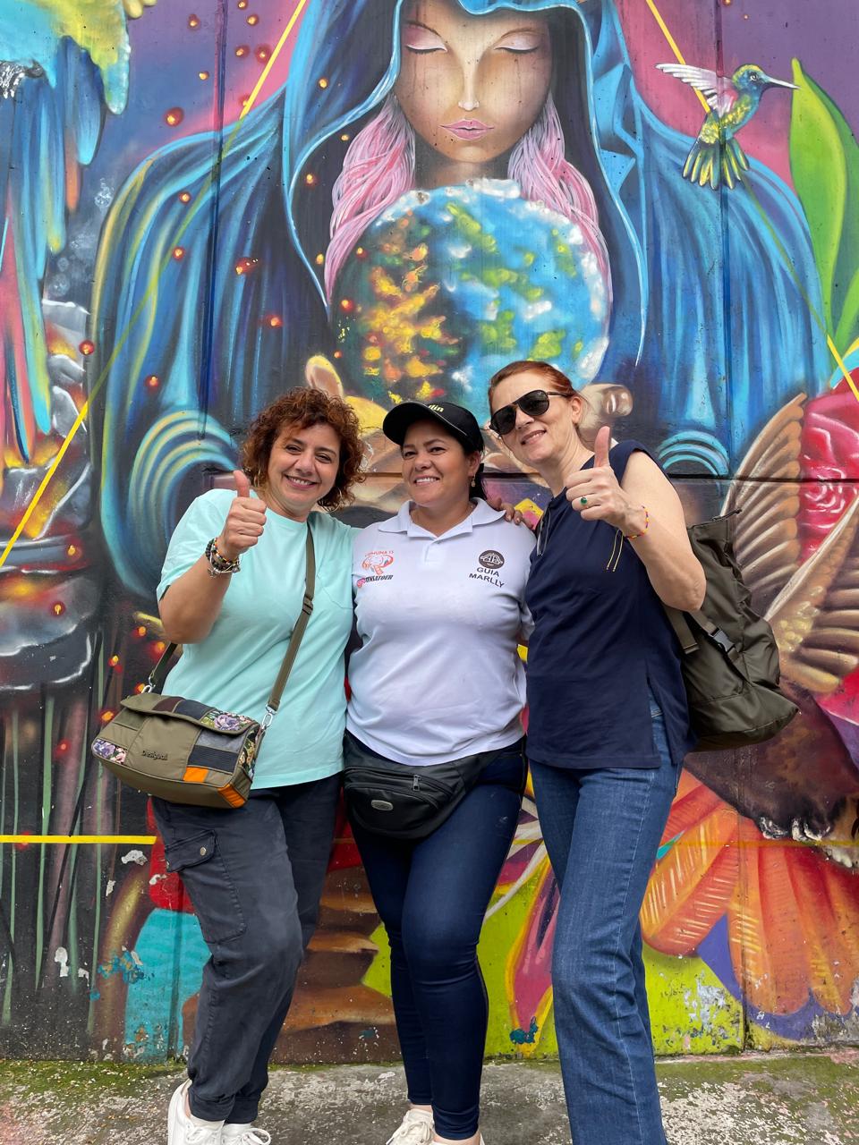 Guests with their Funsatours guide in front of a hummingbird mural